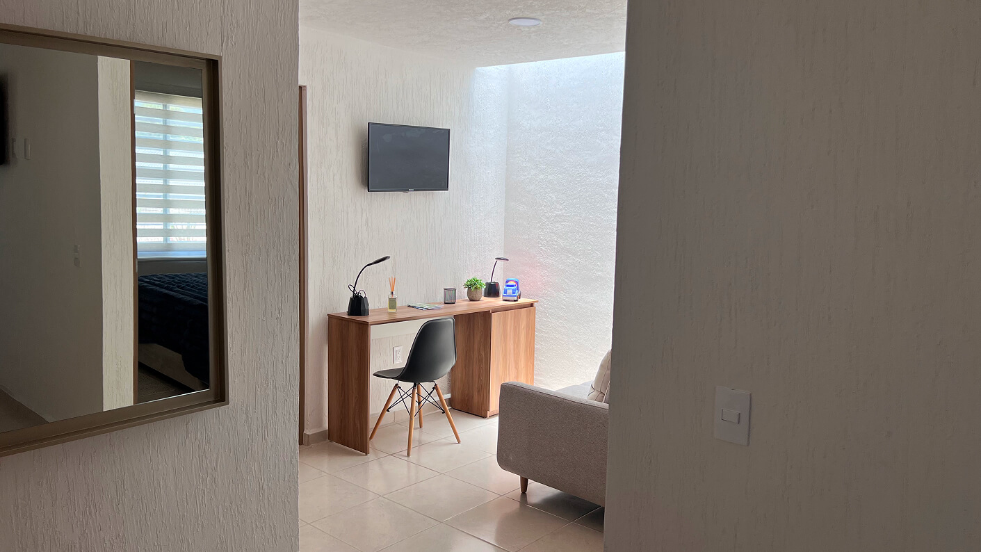 vista de pasillo con escritorio tele sillon y espejo de casa modelo claret en desarrollo residencial paseos de los viñedos en el estado de Aguascalientes Mexico del desarrollo inmobiliario frindsa
