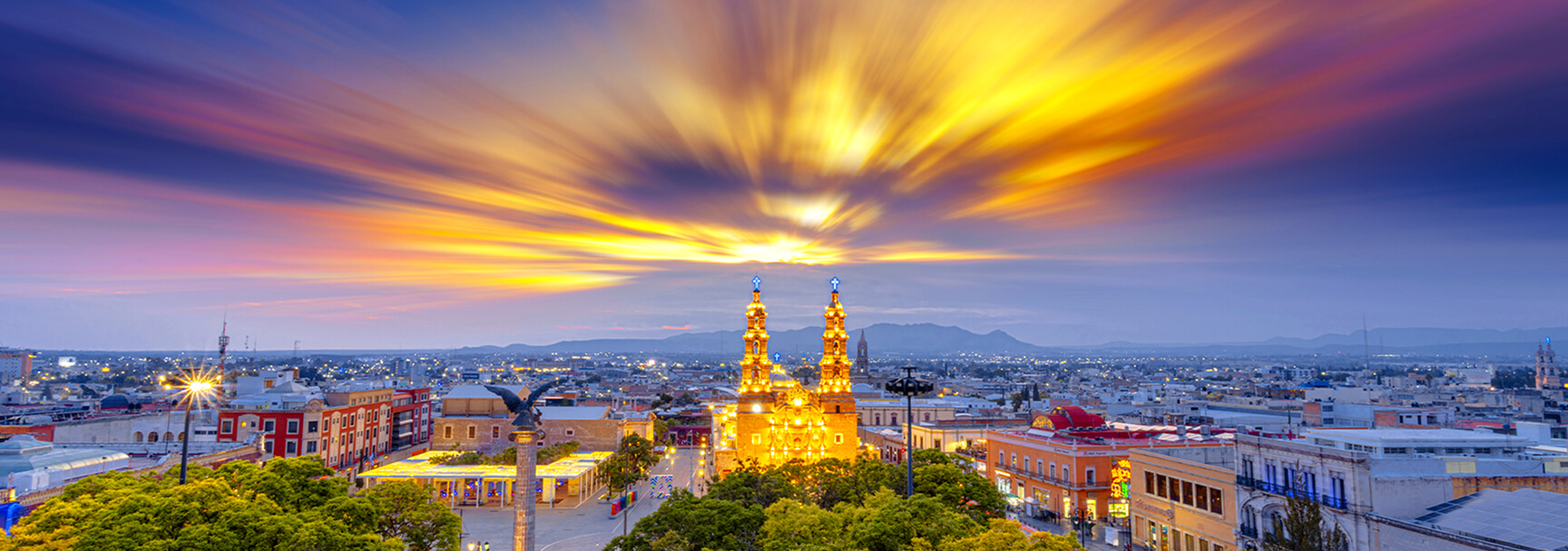Ciudad de Aguascalientes, México, con un imponente torre de iglesia en el primer plano del paisaje urbano.