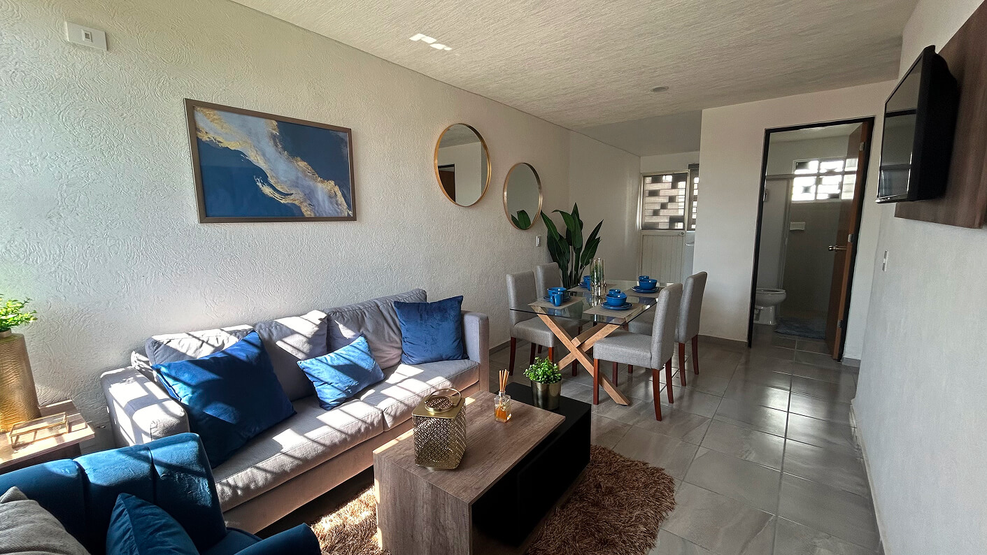 sala de estar con mesa de centro con comedor de fondo de casa modelo capri en desarrollo residencial paseos de la providencia en el estado de Aguascalientes Mexico del desarrollador inmobiliario frindsa