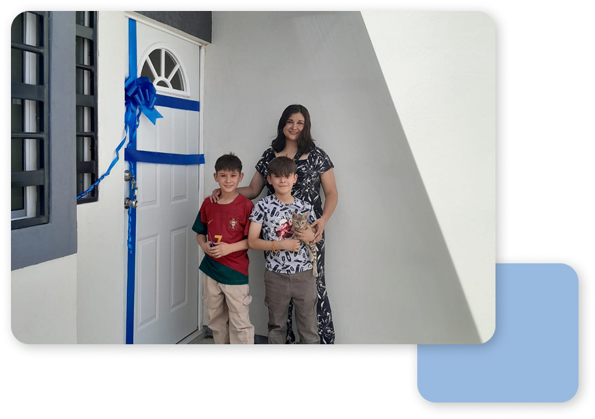 madre a la puerta de su nueva casa de frindsa con sus dos hijos